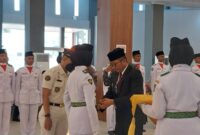 pemasangan kendit kepada perwakilan anggota pasukan Paskibraka Kota Padang. (Diskominfo Padang)