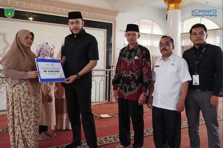 Wali Kota Padang Panjang Fadly Amran menyerahkan zakat kepada mustahik. (Kominfo Padang Panjang)