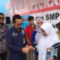 Asisten 1 Setdako Padang Edi Hasymi membagikan TTD kepada siswi.(Diskominfo Padang)