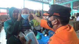 Sekretaris BPBD Kota Padang, Robert Chandra Eka Putra membagikan masker di Pasar Alai, Kamis (5/10/2023). (BPBD Padang)