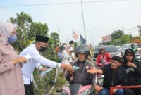 Wako Hendri Septa dan istri membagikan masker kepada pengendara, Kamis (20/10/2023). (Diskominfo Padang)
