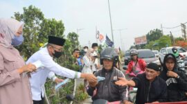 Wako Hendri Septa dan istri membagikan masker kepada pengendara, Kamis (20/10/2023). (Diskominfo Padang) 