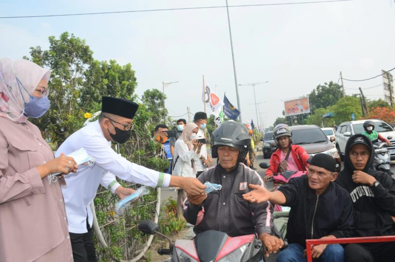 Wako Hendri Septa dan istri membagikan masker kepada pengendara, Kamis (20/10/2023). (Diskominfo Padang) 