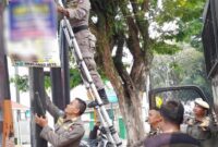 Petugas Satpol PP Padang menertibkan iklan/reklame yang melanggar aturan. (Humas Satpol PP Padang)
