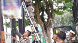 Petugas Satpol PP Padang menertibkan iklan/reklame yang melanggar aturan. (Humas Satpol PP Padang)
