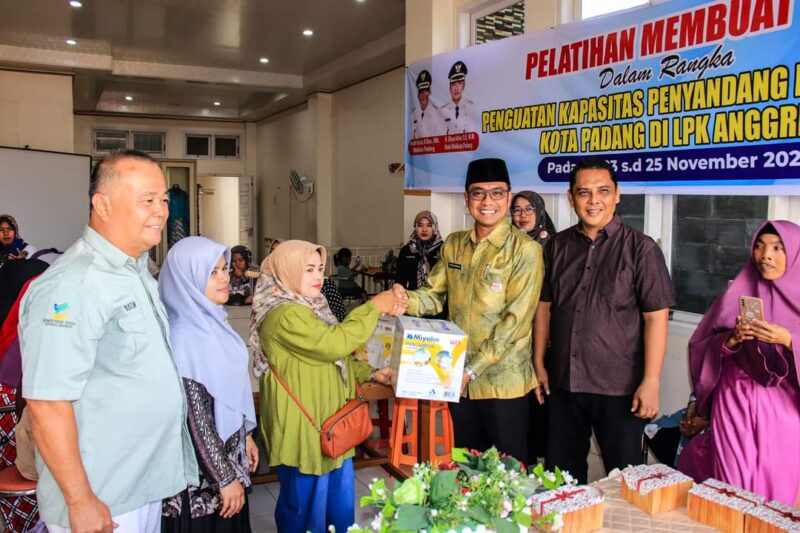 Kepala Dinsos Padang Heriza Syafani menyerahkan bantuan mixer kepada peserta. (Dinsos Padang)
