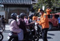 Personil BPBD Kesbangpol Padang Panjang membagikan masker kepada pengguna jalan, kemarin (7/12). (Diskominfo Padang Panjang)