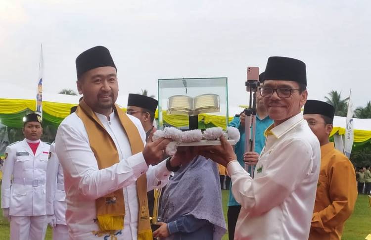 Wakil Gubernur Audy Joinaldy menyerahkan tropy juara umum MTQN XL kepada Bupati Limapuluh Kota Safaruddin. (Humas Kemenag Sumbar)