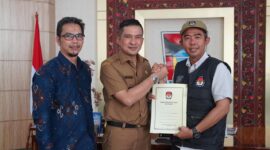 Ketua KPU Padang Riki Eka Putra menyerahkan surat pindah memilih kepada Wawako Ekos Albar. (Dok Prokopim Padang)