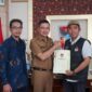 Ketua KPU Padang Riki Eka Putra menyerahkan surat pindah memilih kepada Wawako Ekos Albar. (Dok Prokopim Padang)