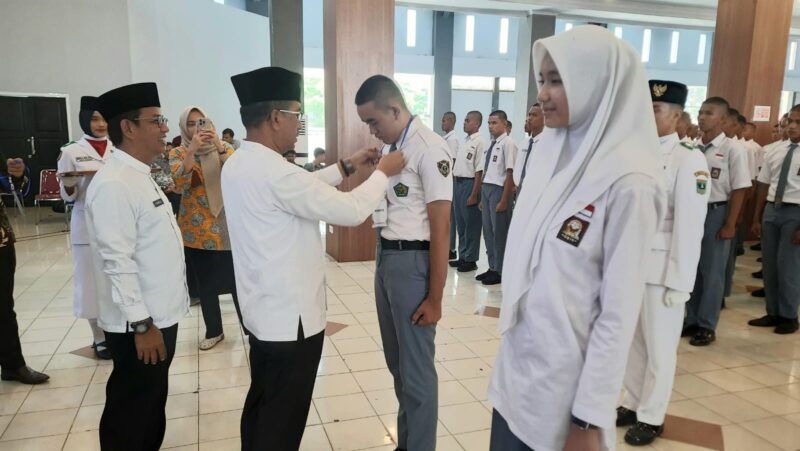 Kepala Disdik Sumbar Barlius didampingi Kepala Badan Kesbangpol Padang Tarmizi Ismail memasangkan kokarde kepada peserta seleksi Paskibraka Kota Padang Tahun 2024, Jumat (1/3/2024).