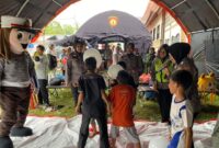 Tim Trauma Healing Polres Tanah Datar menghibur para korban bencana di Posko Pengungsian Kantor Wali Nagari Rambatan, Rabu (15/5/2024). (Foto: Prokopim Tanah Datar)