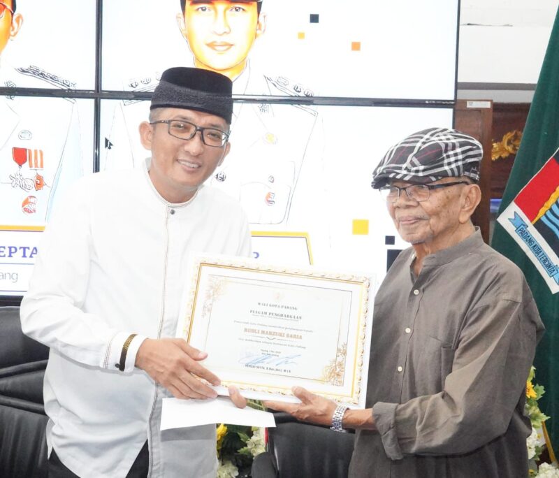 Wali Kota Padang Hendri Septa Dt. Alam Batuah menyerahkan penghargaan kepada Rusli Marzuki Saria, Minggu (5/5/2024). (Foto: Prokopim Padang)