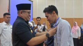 Pj Wako Padang Andree Algamar memasang kokarde kepada peserta. (Foto: Prokopim Padang)