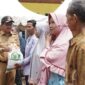 Bupati Khairunas menyerahkan Bantuan Pangan Cadangan Beras Pemerintah periode kedua kepada warga di kantor Camat SBJ, Selasa (28/5/2024). (Foto: Humas Pemkab Solsel)