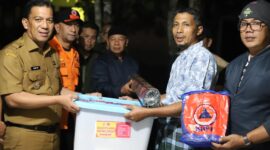 Pj Wali Kota, Sonny Budaya Putra menyerahkan bantuan kepada warga yang terdampak banjir bandang lahar dingin, Selasa (14/5/2024) malam. (Foto: Kominfo Padang Panjang)