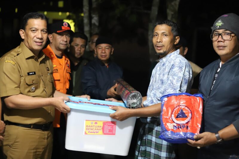 Pj Wali Kota, Sonny Budaya Putra menyerahkan bantuan kepada warga yang terdampak banjir bandang lahar dingin, Selasa (14/5/2024) malam. (Foto: Kominfo Padang Panjang)