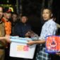 Pj Wali Kota, Sonny Budaya Putra menyerahkan bantuan kepada warga yang terdampak banjir bandang lahar dingin, Selasa (14/5/2024) malam. (Foto: Kominfo Padang Panjang)