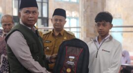 Ketua Baznas Padang H. Yuspardi menyerahkan bantuan perlengkapan sekolah kepada siswa. (Foto: Baznas Padang)