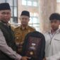 Ketua Baznas Padang H. Yuspardi menyerahkan bantuan perlengkapan sekolah kepada siswa. (Foto: Baznas Padang)