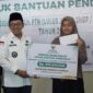 Bupati Tanah Datar Eka Putra menyerahkan secara simbolis bantuan pendidikan kepada mahasiswa dari keluarga kurang mampu. (Foto: Prokopim Tanah Datar)
