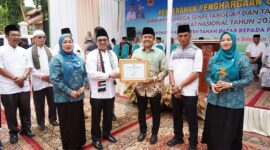 Bupati Tanah Datar Eka Putra bersama Ketua TP PKK Ny. Lise Eka Putra menyerahkan penghargaan kepada Wali Nagari Tapi Selo Genta Maulana Akbar. (Foto: Prokopim Tanah Datar)