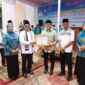 Bupati Tanah Datar Eka Putra bersama Ketua TP PKK Ny. Lise Eka Putra menyerahkan penghargaan kepada Wali Nagari Tapi Selo Genta Maulana Akbar. (Foto: Prokopim Tanah Datar)