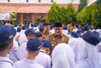 Pj Wali Kota Padang Andree Algamar menyalami para siswa usai membuka MPLS di SMPN 1 Padang, Senin (15/7/2024).