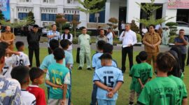Pj. Wali Kota Pariaman, Roberia menyerahkan secara sombolis bantuan bola kaki kepada 6 SSB di halaman Balaikota, Selasa (2/7/2024). (Foto: Diskominfo Kota Pariaman)