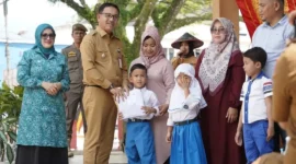 Bupati Solsel Khairunas menyerahkan secara simbolis seragam sekolah gratis kepada siswa. (Foto: Humas Pemkab Solsel)