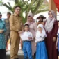 Bupati Solsel Khairunas menyerahkan secara simbolis seragam sekolah gratis kepada siswa. (Foto: Humas Pemkab Solsel)