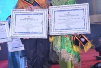 Pj Wako Padang Andree Algamar dan istri, Vanny Andree Algamar menerima anugerah Ayah dan Bunda GenRe Sumbar 2024 kategori Pengayom. (Foto: Prokopim Padang)