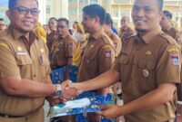 Pj Sekda Padang Yosefriawan menyerahkan penghargaan kepada Faisal Siregar, ASN Bagian Prokopim Setdako Padang. (Foto: Prokopim Padang)