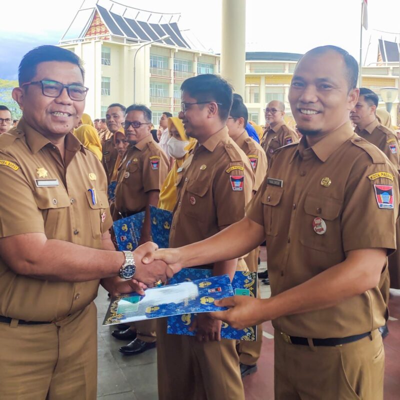 Pj Sekda Padang Yosefriawan menyerahkan penghargaan kepada Faisal Siregar, ASN Bagian Prokopim Setdako Padang. (Foto: Prokopim Padang)