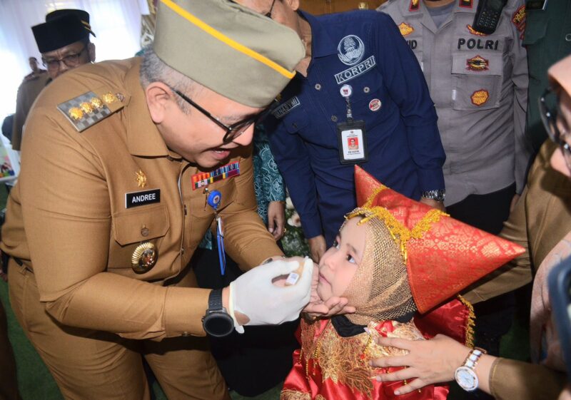 Pj Wali Kota Padang Andree Algamar secara simbolis memberikan imunisasi kepada salah seorang anak. (Foto: Prokopim Padang)