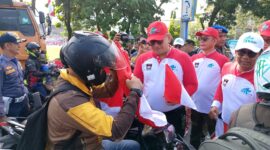 Pj Wali Kota Padang Andree Algamar membagikan bendera merah putih kepada pengguna jalan di depan Kantor Balai Kota Padang, Rabu (31/7/2024). 