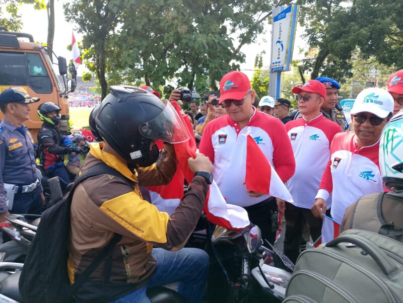 Pj Wali Kota Padang Andree Algamar membagikan bendera merah putih kepada pengguna jalan di depan Kantor Balai Kota Padang, Rabu (31/7/2024). 