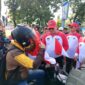 Pj Wali Kota Padang Andree Algamar membagikan bendera merah putih kepada pengguna jalan di depan Kantor Balai Kota Padang, Rabu (31/7/2024). 