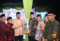 Pj Wali Kota Padang Andree Algamar menyerahkan trophy juara umum MTQN ke-41 Tingkat Kota Padang kepada Camat Kototangah Fizlan Setiawan. (Foto: Prokopim Padang)