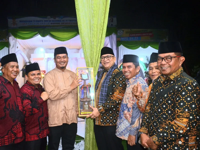 Pj Wali Kota Padang Andree Algamar menyerahkan trophy juara umum MTQN ke-41 Tingkat Kota Padang kepada Camat Kototangah Fizlan Setiawan. (Foto: Prokopim Padang)