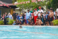 Pj Wali Kota Padang Andree Algamar bersama Ketua TP PKK Padang Ny. Vanny Andree Algamar menyaksikan lomba renang di kolam renang Kawana Hotel, Minggu (25/8/2024). (Foto: Prokopim Padang)