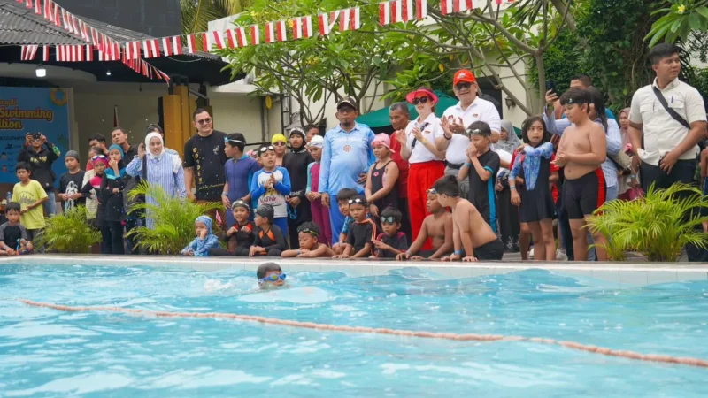 Pj Wali Kota Padang Andree Algamar bersama Ketua TP PKK Padang Ny. Vanny Andree Algamar menyaksikan lomba renang di kolam renang Kawana Hotel, Minggu (25/8/2024). (Foto: Prokopim Padang)