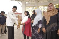 Wabup Solsel Yulian Efi menyerahkan beras cadangan pangan pemerintah (BP-CBP) tahap ketiga untuk keluarga penerima manfaat (KPM) di wilayah Kecamatan Sangir. (Foto: Pemkab Solsel)