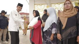 Wabup Solsel Yulian Efi menyerahkan beras cadangan pangan pemerintah (BP-CBP) tahap ketiga untuk keluarga penerima manfaat (KPM) di wilayah Kecamatan Sangir. (Foto: Pemkab Solsel)