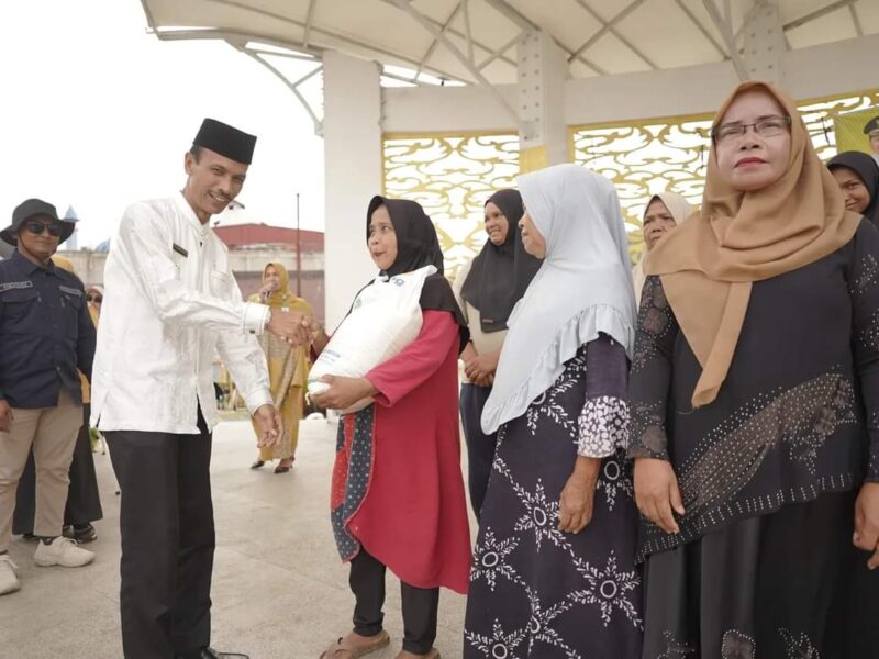 Wabup Solsel Yulian Efi menyerahkan beras cadangan pangan pemerintah (BP-CBP) tahap ketiga untuk keluarga penerima manfaat (KPM) di wilayah Kecamatan Sangir. (Foto: Pemkab Solsel)