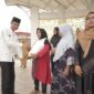 Wabup Solsel Yulian Efi menyerahkan beras cadangan pangan pemerintah (BP-CBP) tahap ketiga untuk keluarga penerima manfaat (KPM) di wilayah Kecamatan Sangir. (Foto: Pemkab Solsel)