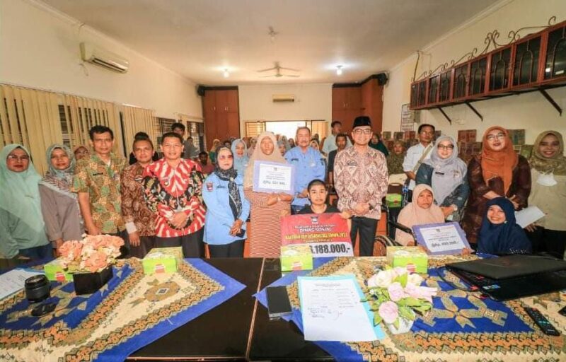 Kepala Dinsos Padang Heriza Syafani menyerahkan bantuan permakanan dan UEP kepada penyandang disabilitas dan lansia. (Foto: Dinsos Padang)