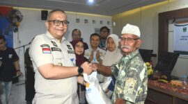 Pj Wali Kota Padang, Andree Algamar menyerahkan bantuan pangan tahap III berupa beras kepada warga. (Foto: Prokopim Padang)