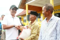 Bupati Solok Selatan Khairunas menyerahkan bantuan beras kepada warga, Minggu (8/9/2024). (Foto: IST)