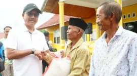 Bupati Solok Selatan Khairunas menyerahkan bantuan beras kepada warga, Minggu (8/9/2024). (Foto: IST)